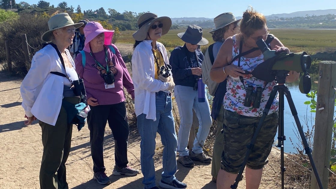 Members of the Osher Lifelong Learning Institute on a trail, birdwatching and enjoying nature.