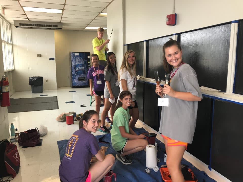 Students painting for a community project