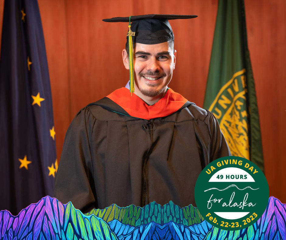 Cody Kapotak, Coeng student, posing in a pic, with grad cap and gown on. Infront of UAA and AK flags