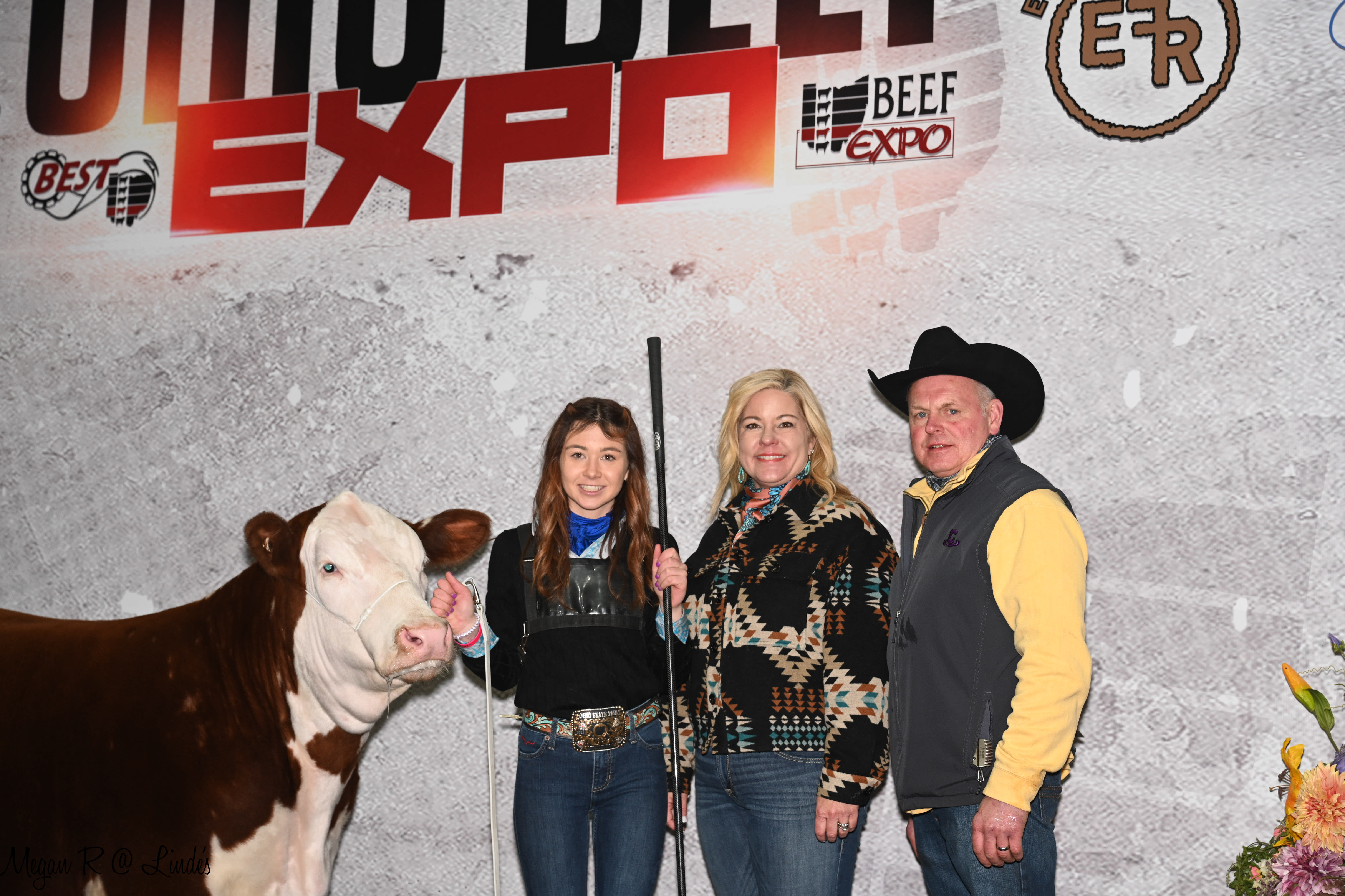 Three individuals standing next to a steer at the Ohio Beef Expo