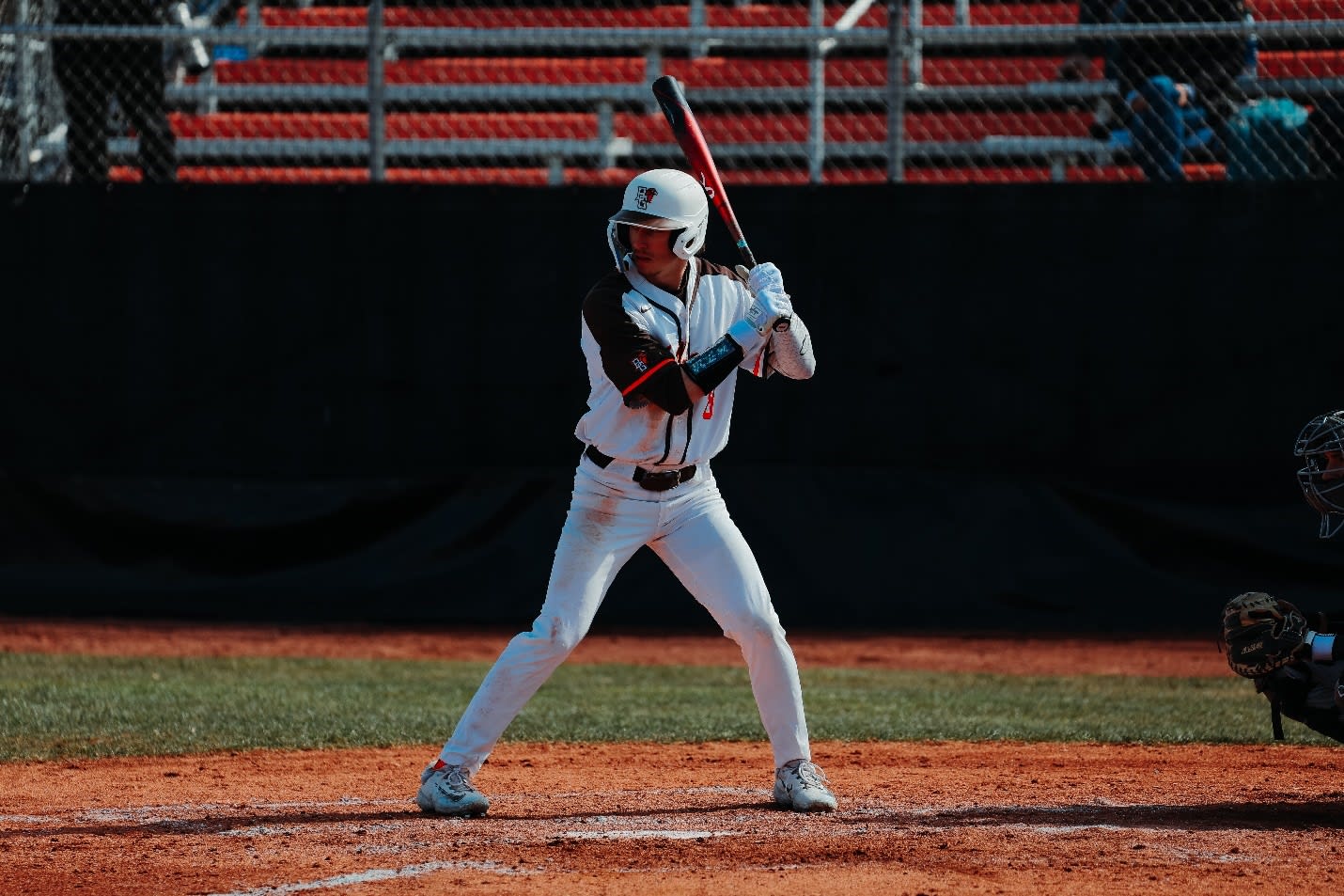 A baseball player in a white uniform holding a bat

Description automatically generated