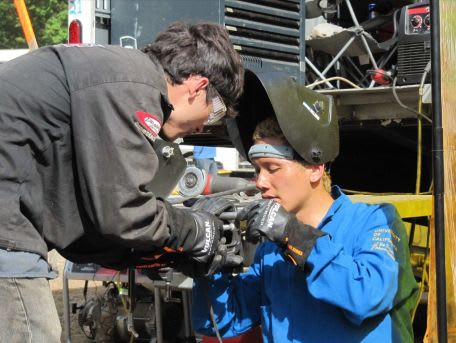 Two students working on an engine.