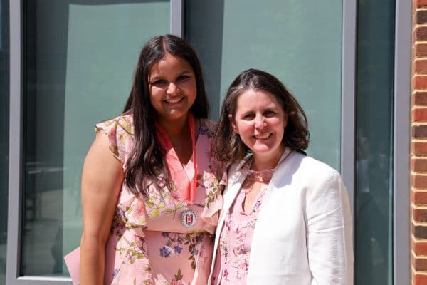 Student smiling for a photo outside with their mentor