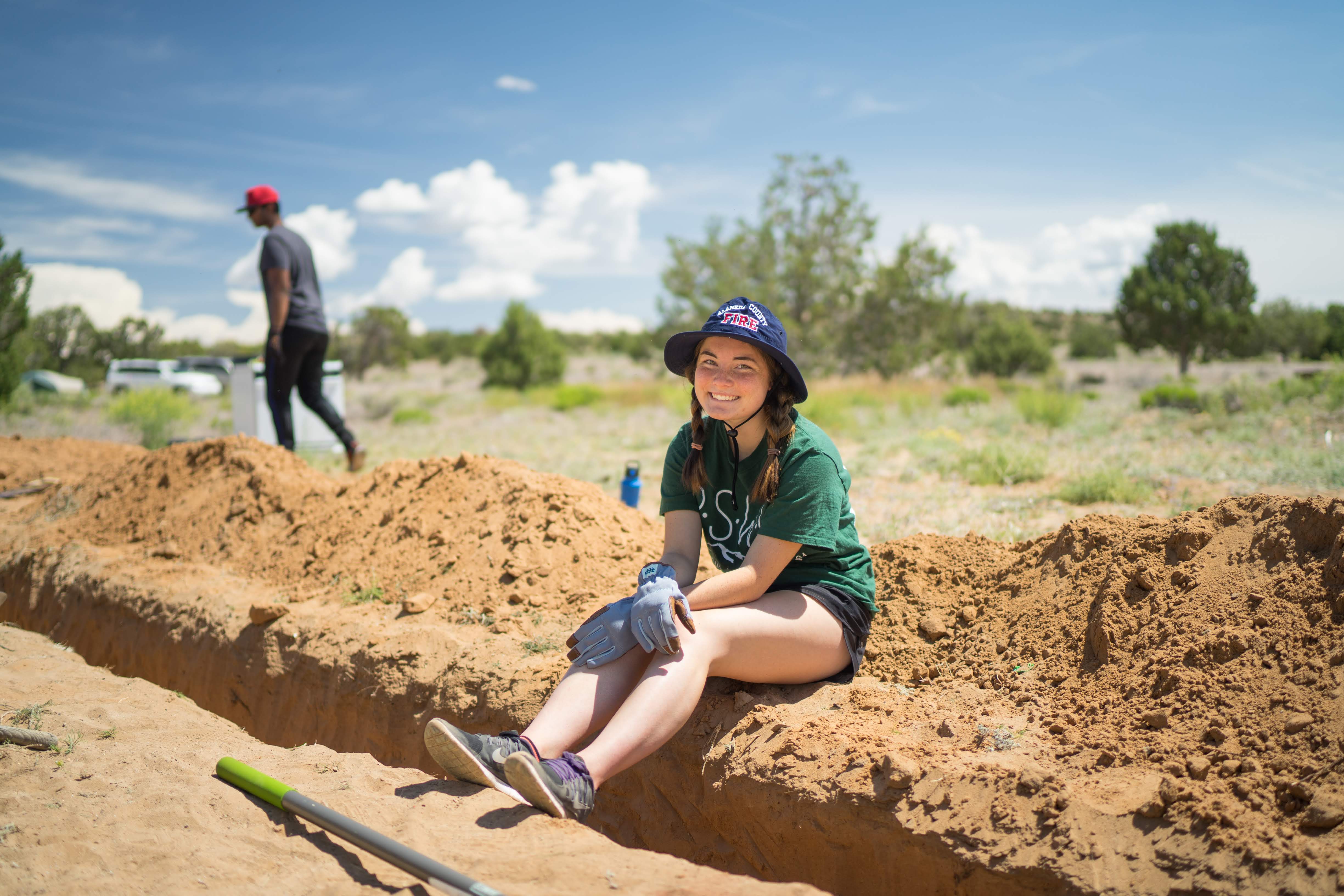 Project Member taking a break after hard work digging a trench for the grey water system.