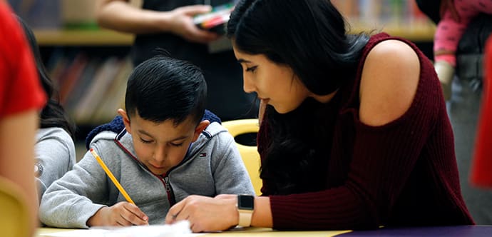 A Fresno State student helps a young child learn how to read.