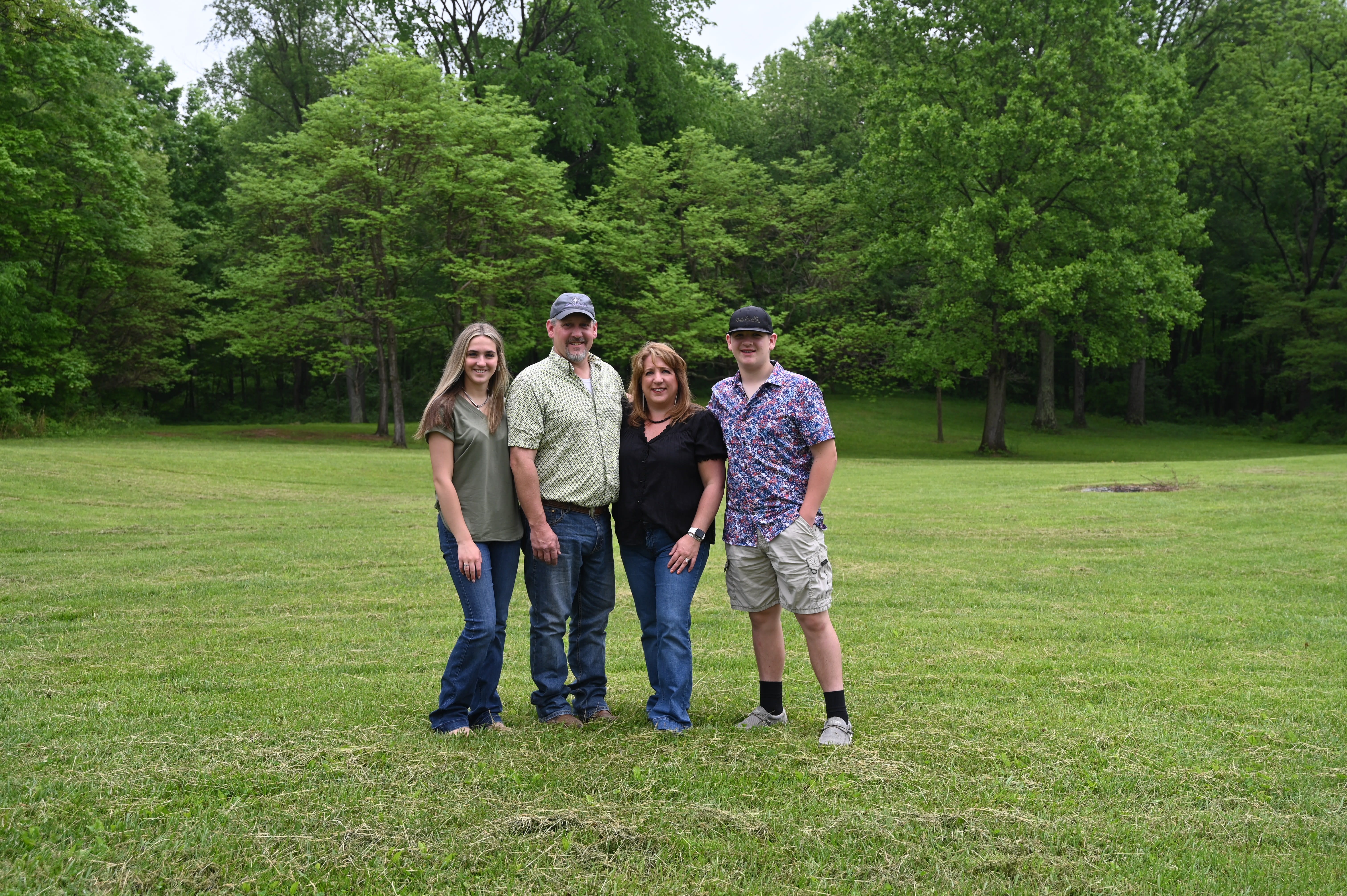 Four members of the Yochum Family pose together before a treeline