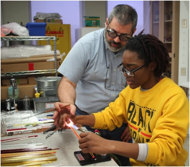 Student measuring alongside a faculty member