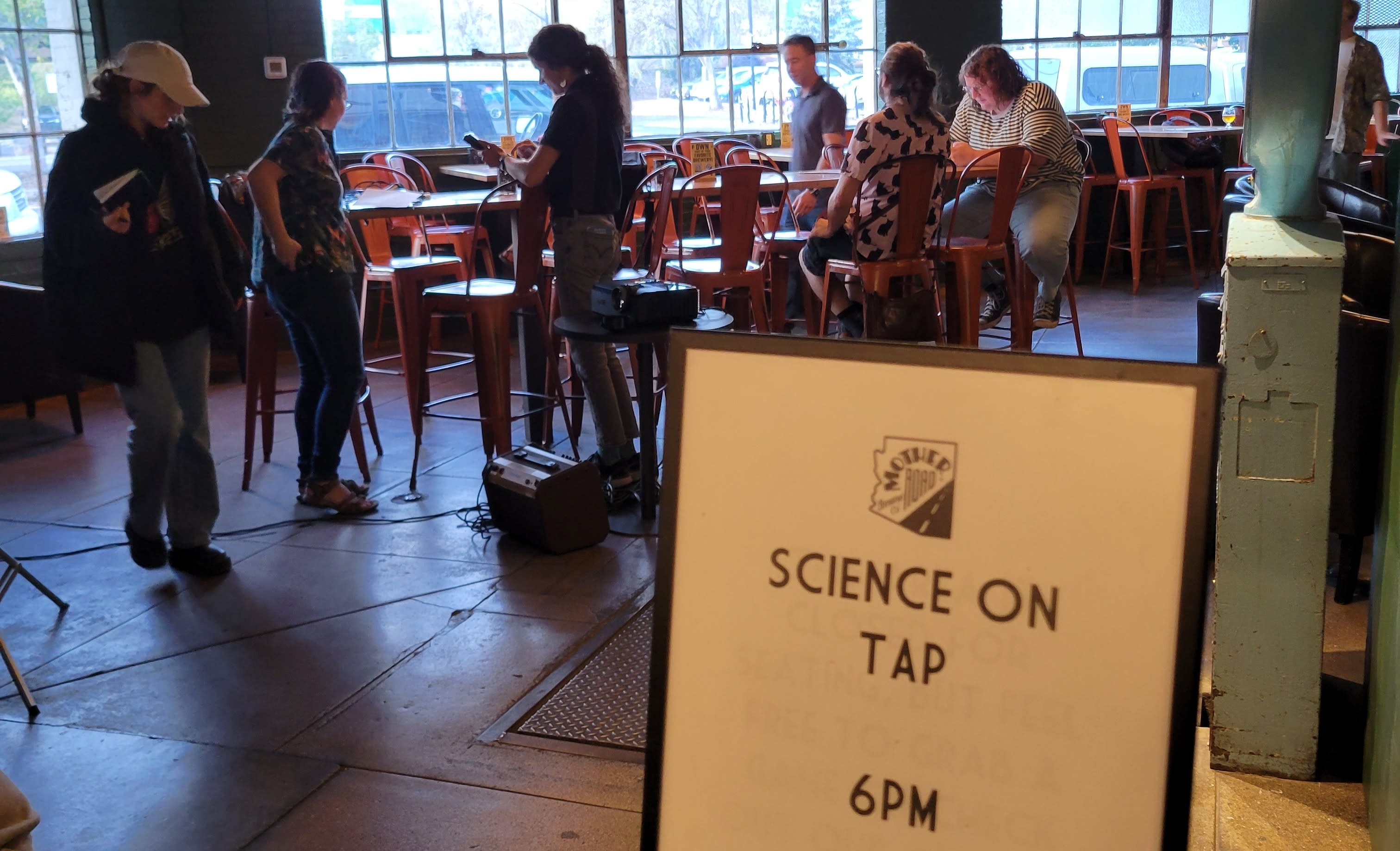 Image of the Science on Tap event sign in a dimly lit bar.