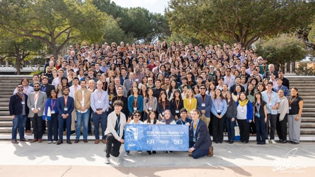 An outdoor group picture of dozens of students, staff and professors lined up on a set of stairs. A smaller group in the front holds up a banner with "2026 Western District ITE" visible along with various logos.