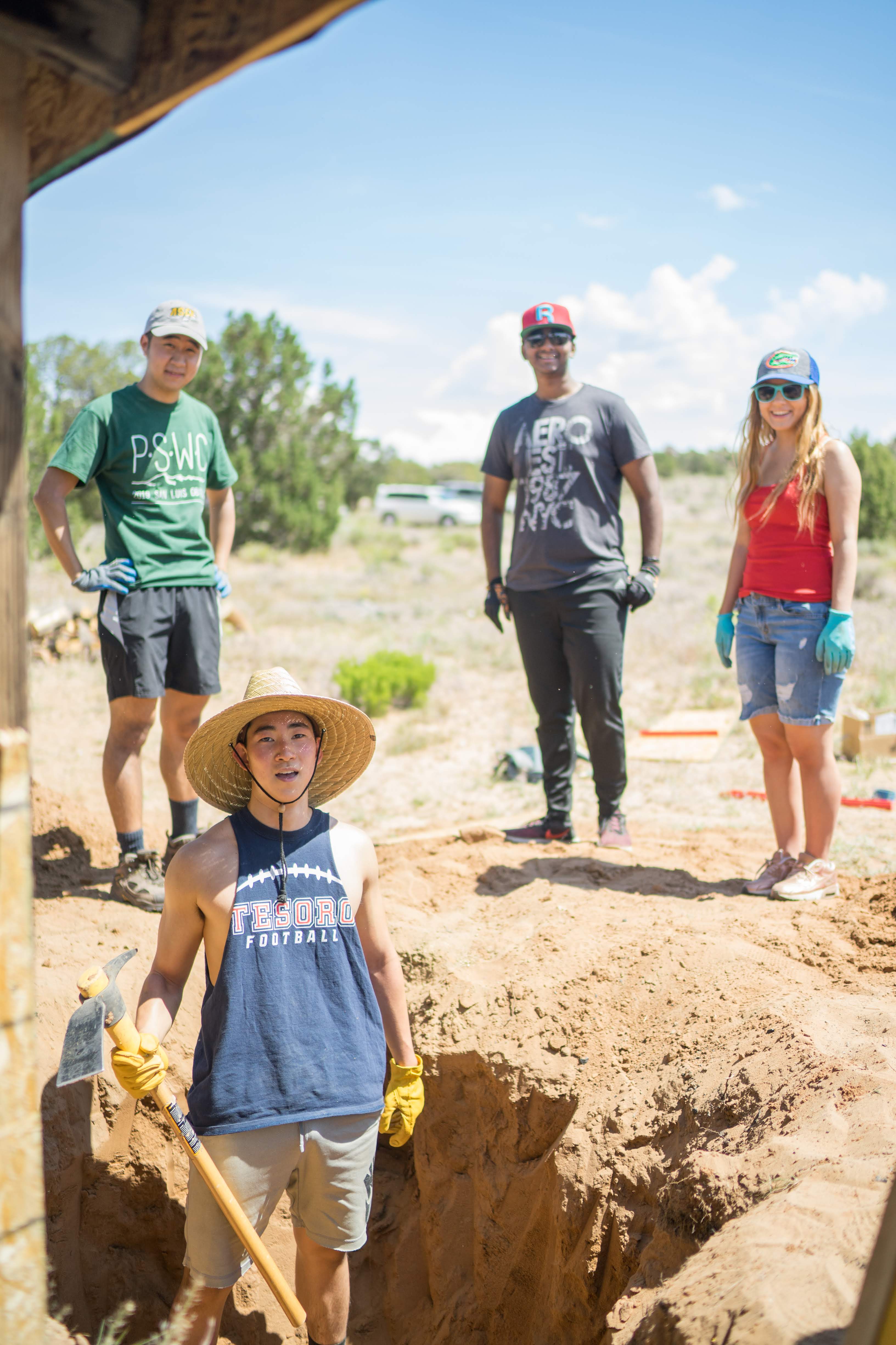 Team members pose while digging the hole for the tank.