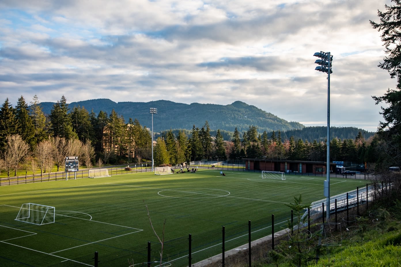 A football field with trees and mountains in the background

Description automatically generated with medium confidence