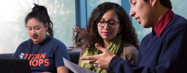 2 students looking at a piece of paper and talking