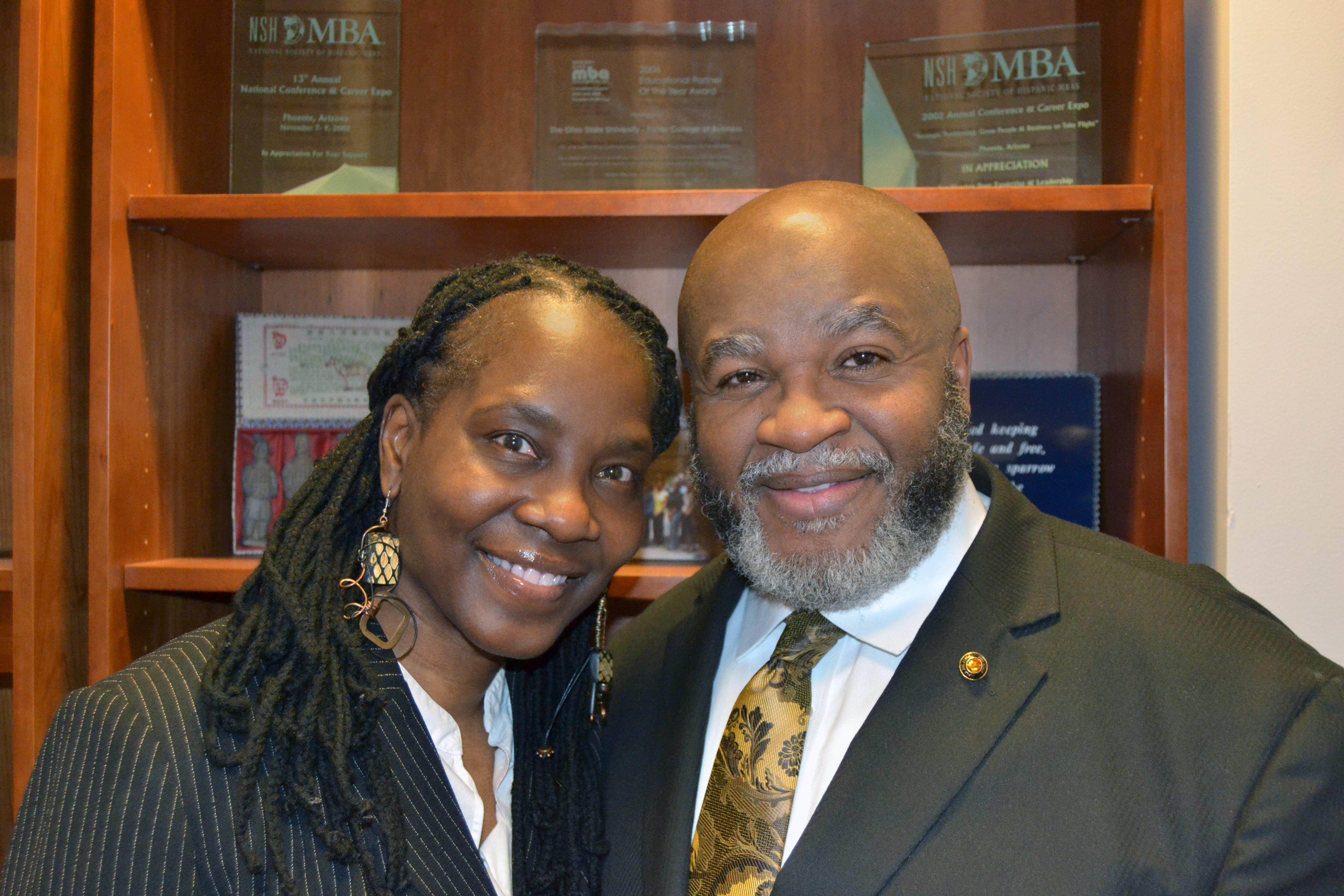 David Harrison and a woman stand before a glass case. Both are wearing professional attire