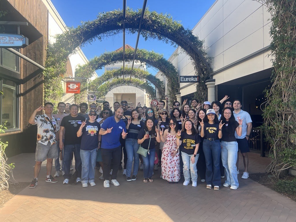  Young Alumni Chapter smiling and holding up zots outside of Eureka! Restaurant at the University Town Center. 