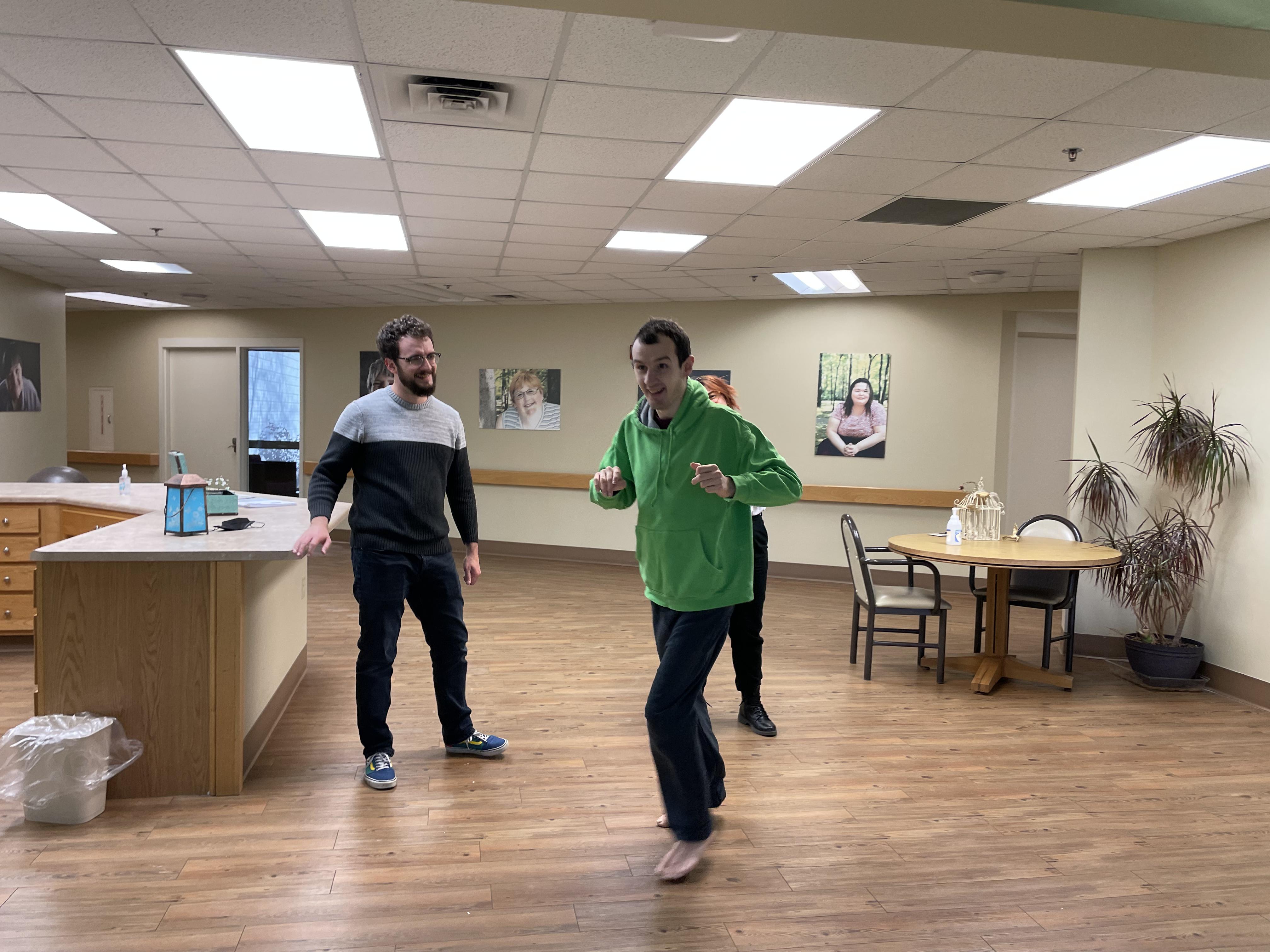 Individual dancing in the hospital with two other people