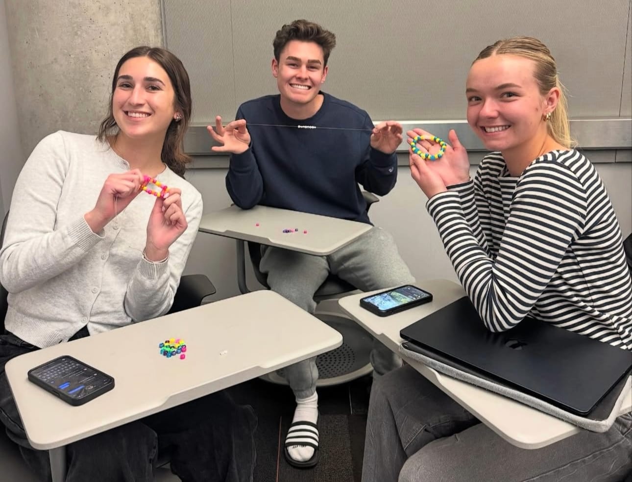 Three Dental Brigade students at a club social event making bracelets