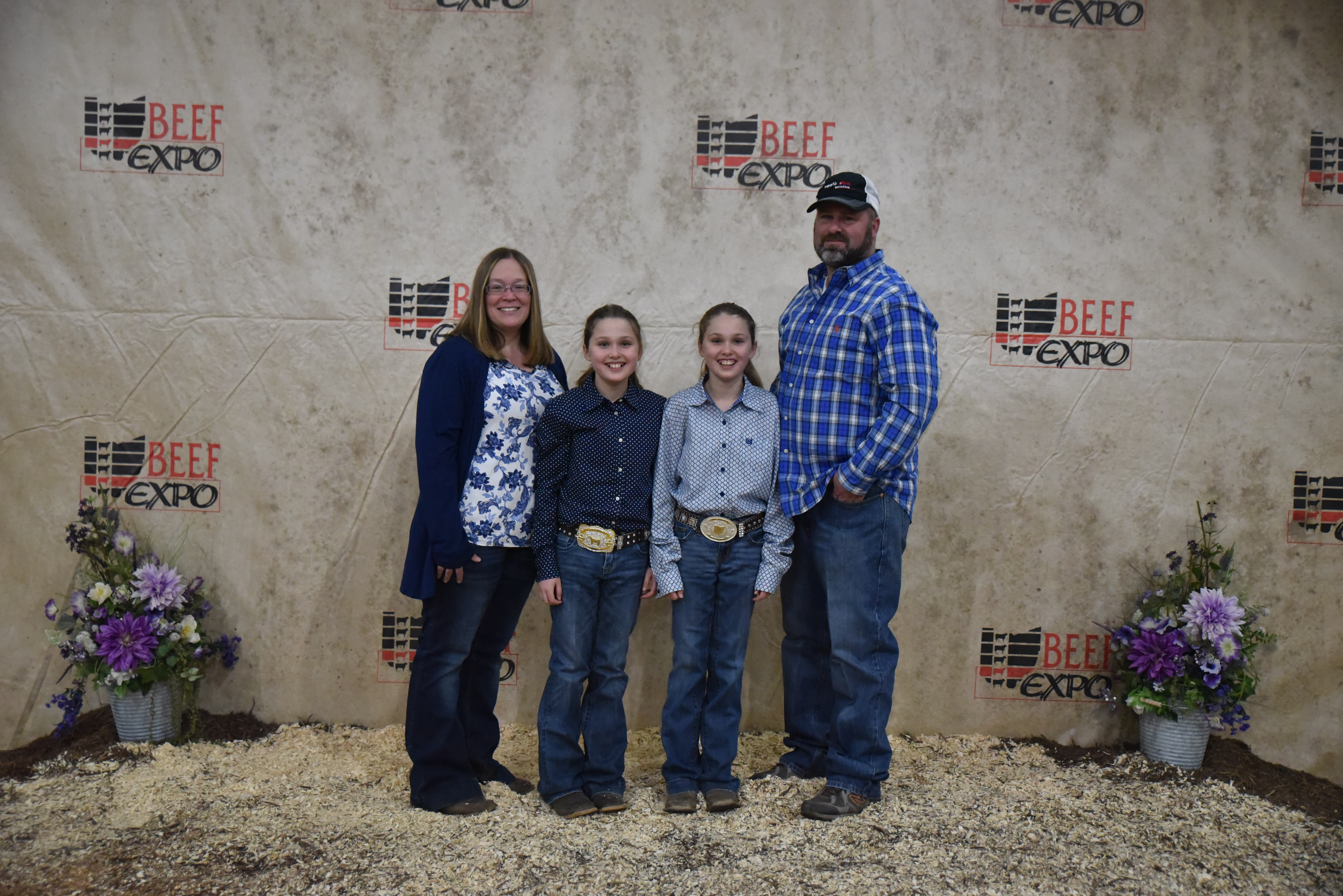 Four members of the Poff Family stand before the Beef Expo backdrop