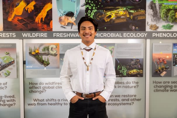 Student posing in front of science posters