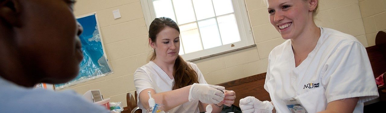 Image: NACU students speaking with a patient