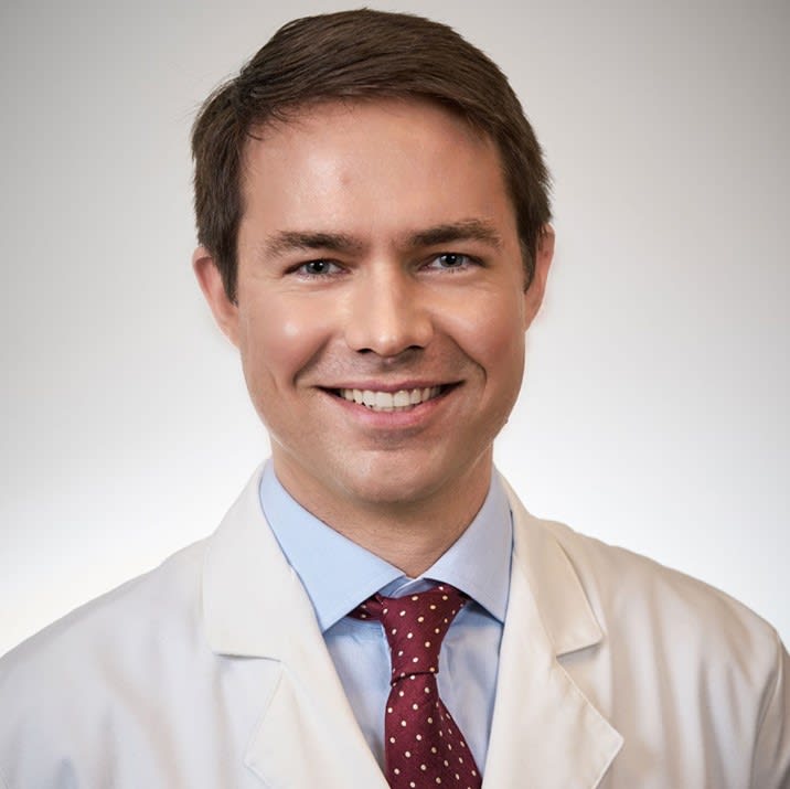 Dr. James S. Blachly headshot. He is wearing a dress shirt with a doctor's coat on top