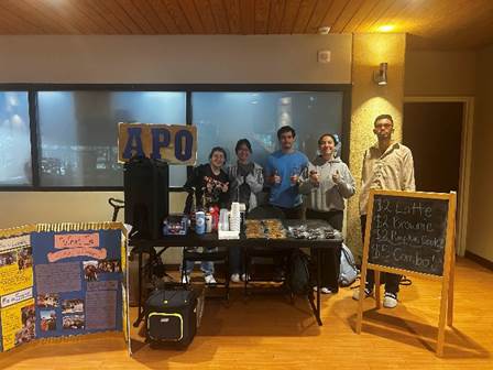 A group of people standing in front of a table
AI-generated content may be incorrect.