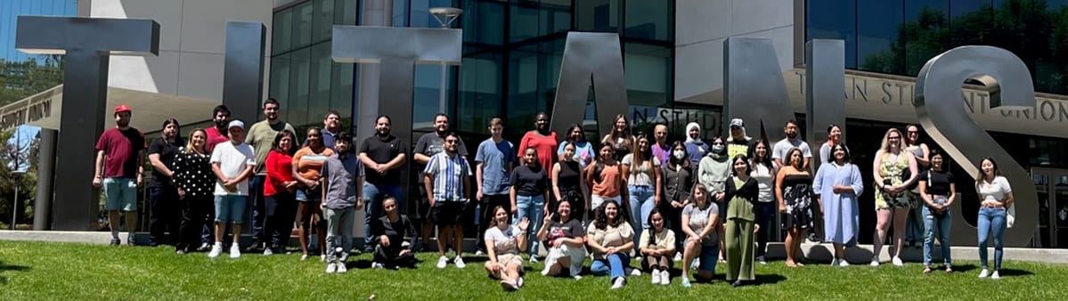 TAPP center opening attendees in front of Titan sign