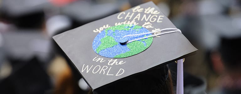 Graduation cap with "Be the change you wish to be in the world" wriiten on it.