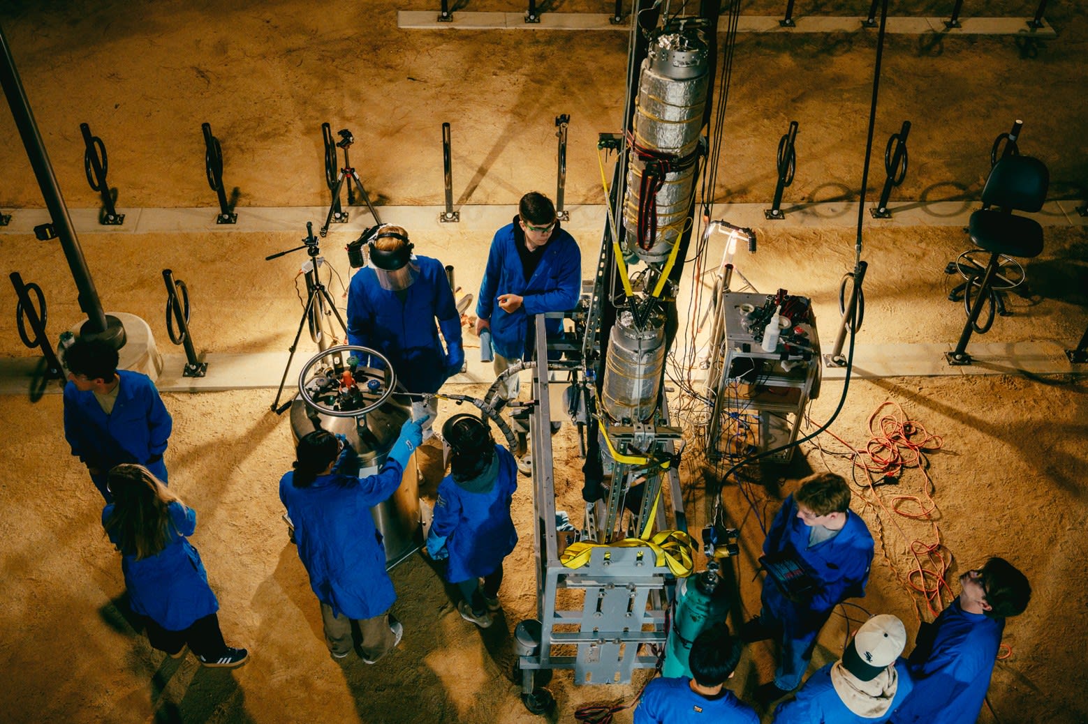 An image of the team taken from above; everyone in the group is hard at work around the rocket, preparing for the test fire.