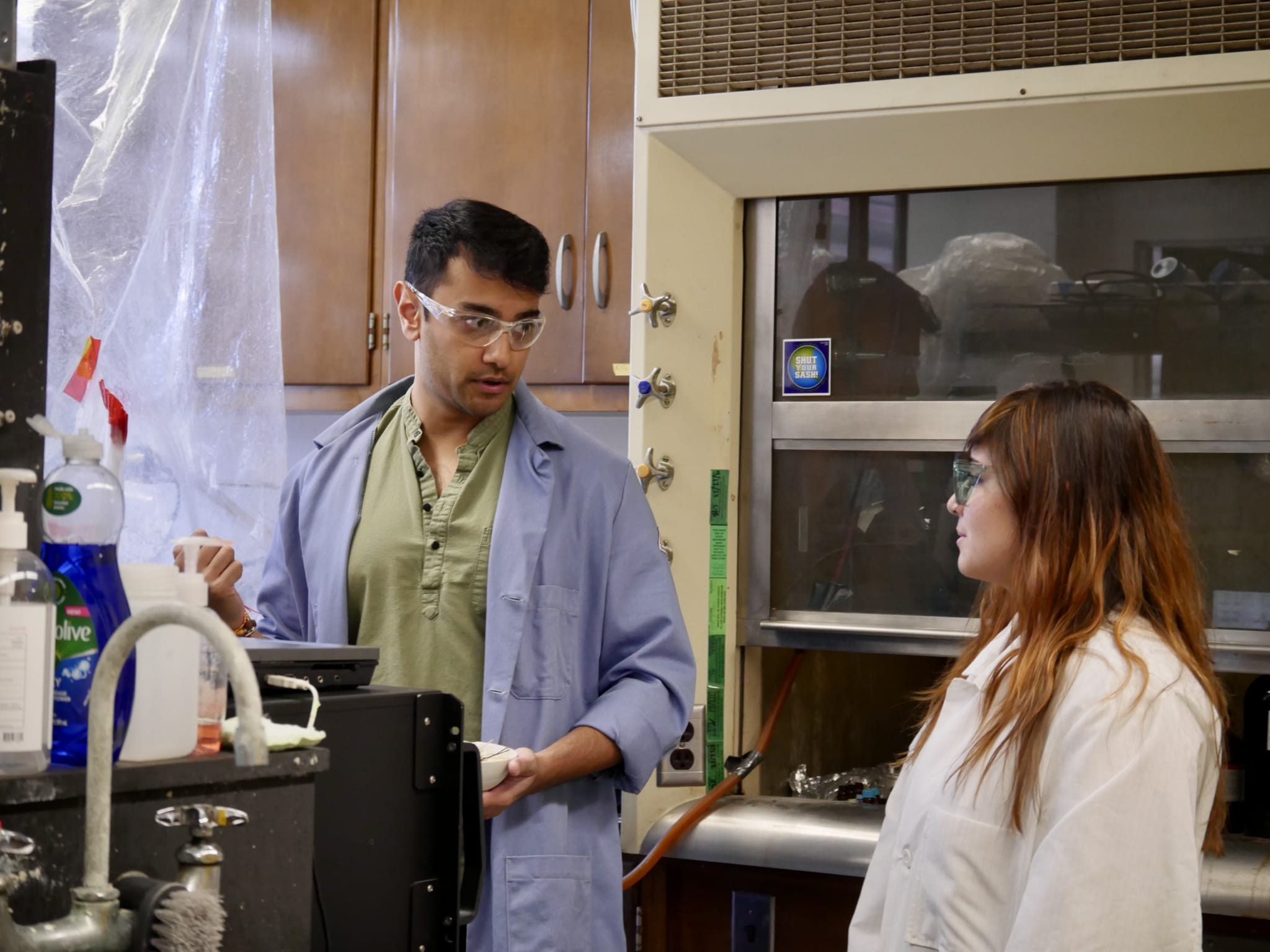 ESE student Saagar Patel demonstrates how to simulate wildfires in the lab to model air pollution toxicity with fellow student Kelli Fletcher.