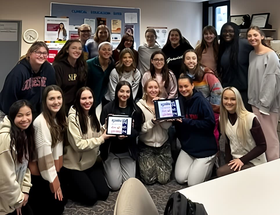 Group of health science students holding Day of Giving sign
