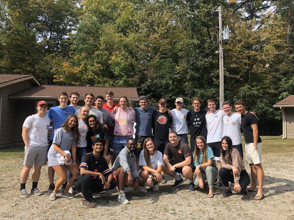Members of the fraternity gather outside, huddled close for a picture 