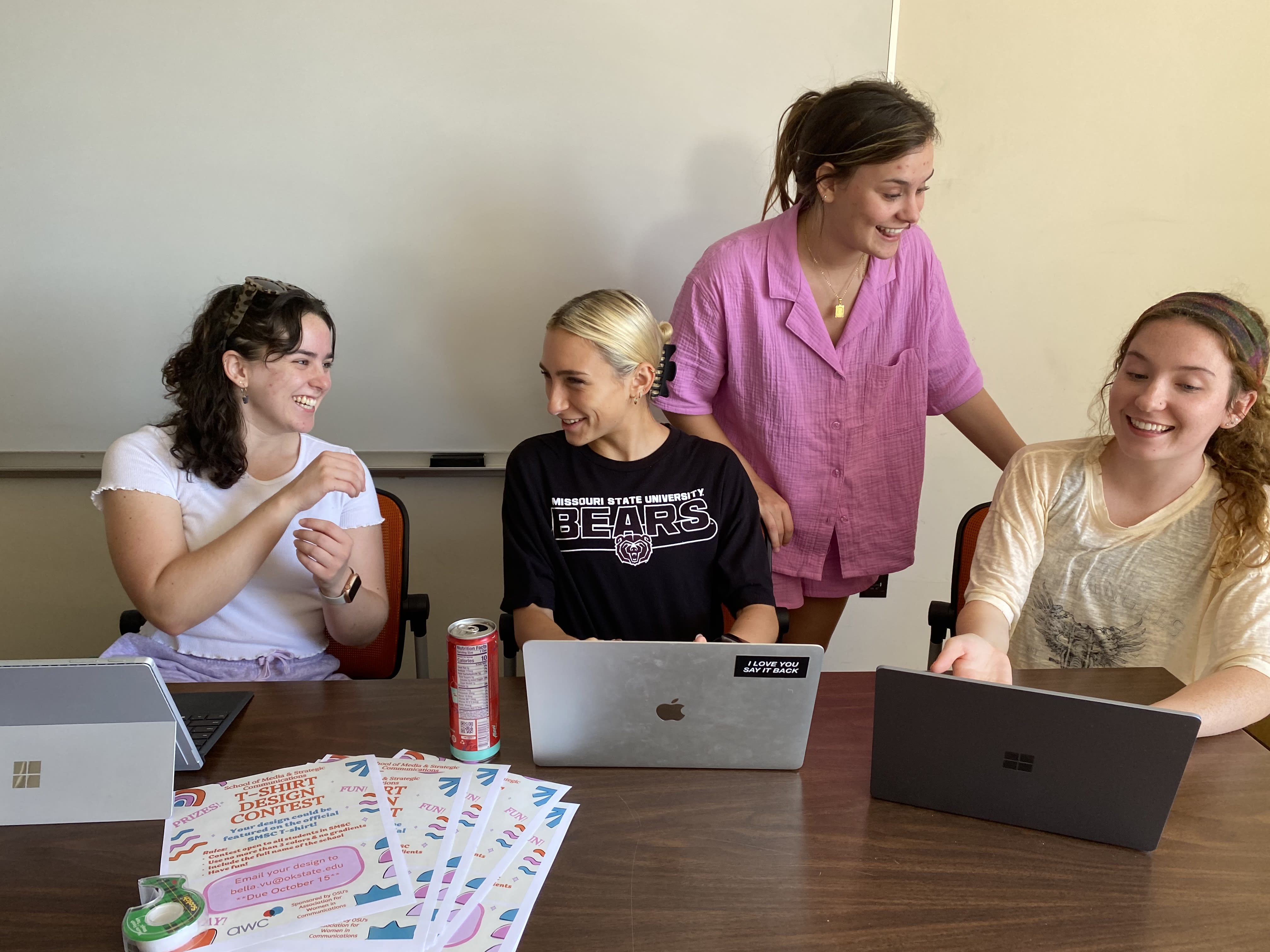 Four members of AWC sit at their laptops working on campaign planning and communications.