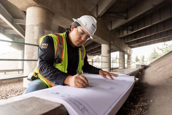Construction Management student writing a note on some schematics