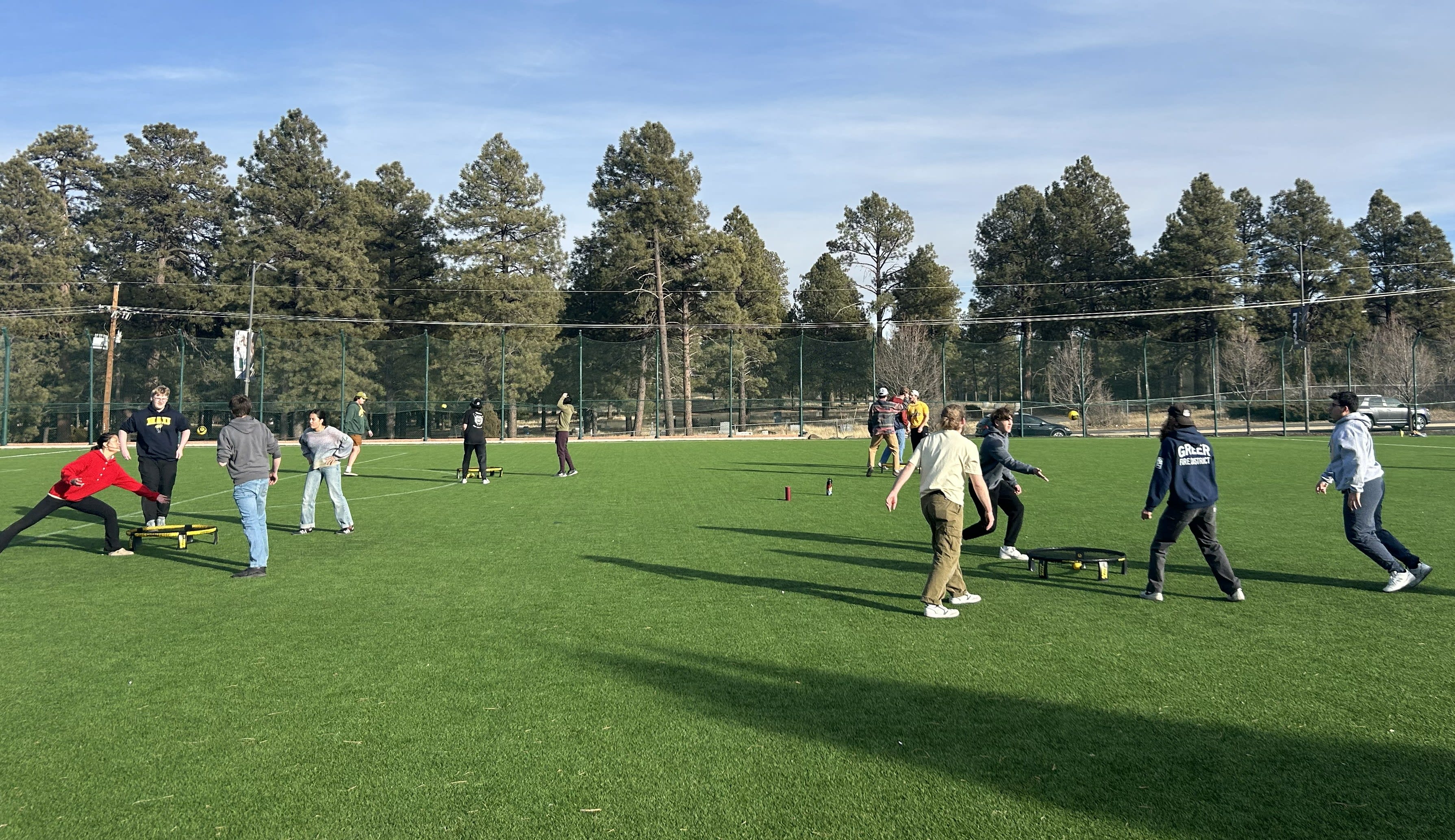 20 students are playing spikeball on a chilly morning