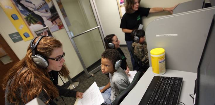 student testing hearing of child child wearing headphones