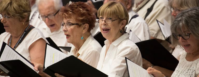 4 women as part of the chorus singing