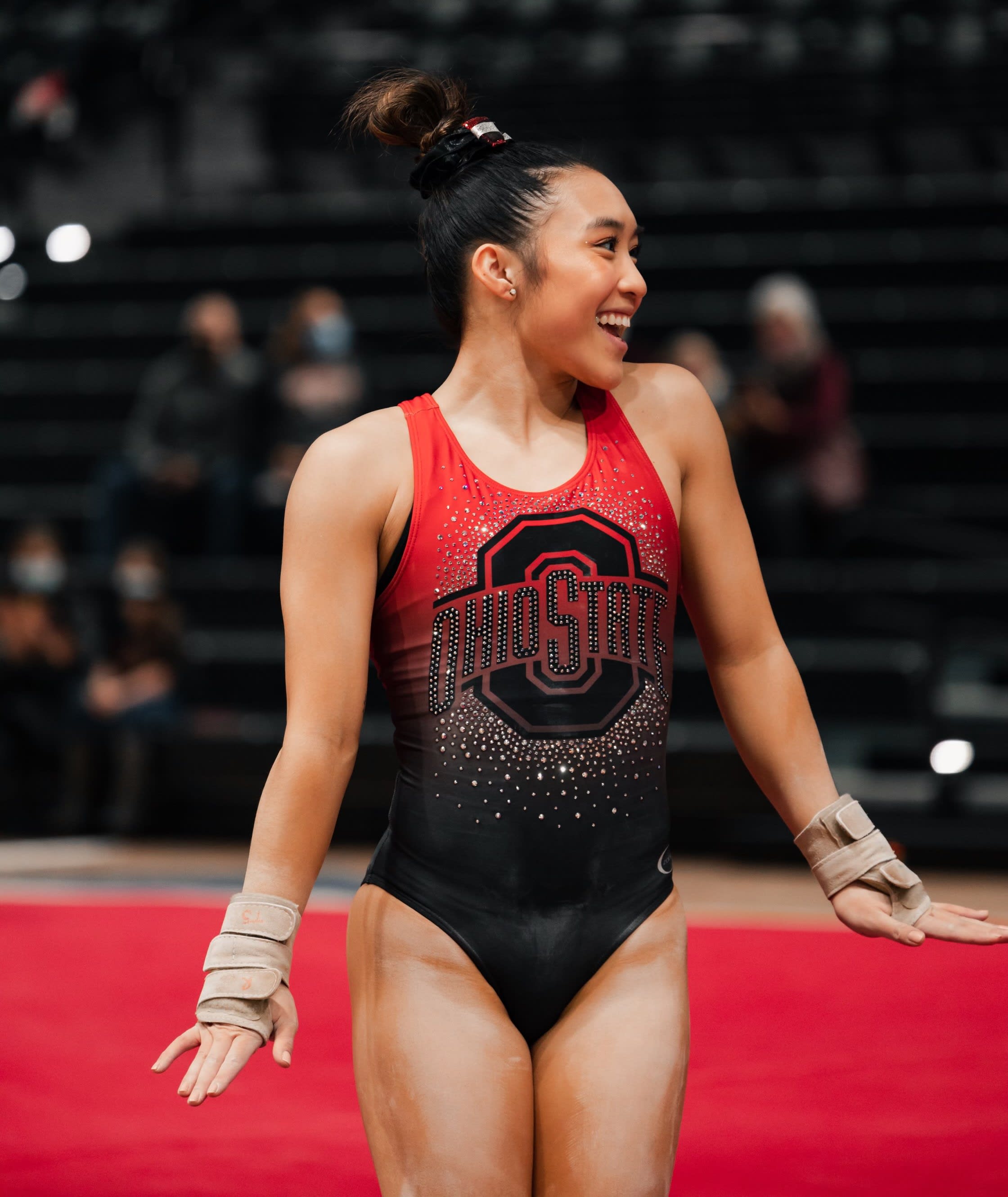 Gymnast posing after she completes a routine 