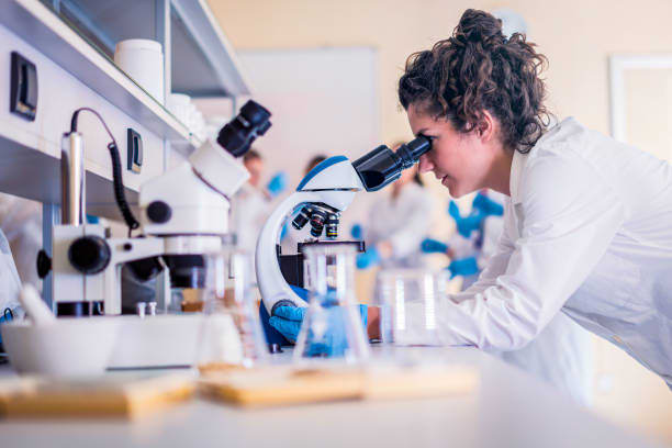 Scientists in laboratory working on research Scientist in lab doing research and using lab machines, test tubes, microscope and every laboratory equipment chemistry student stock pictures, royalty-free photos & images