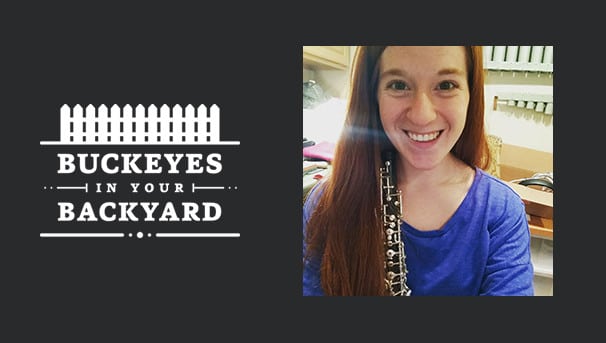 Ashley Miley in an instrument room holding a clarinet against her chest and shoulder