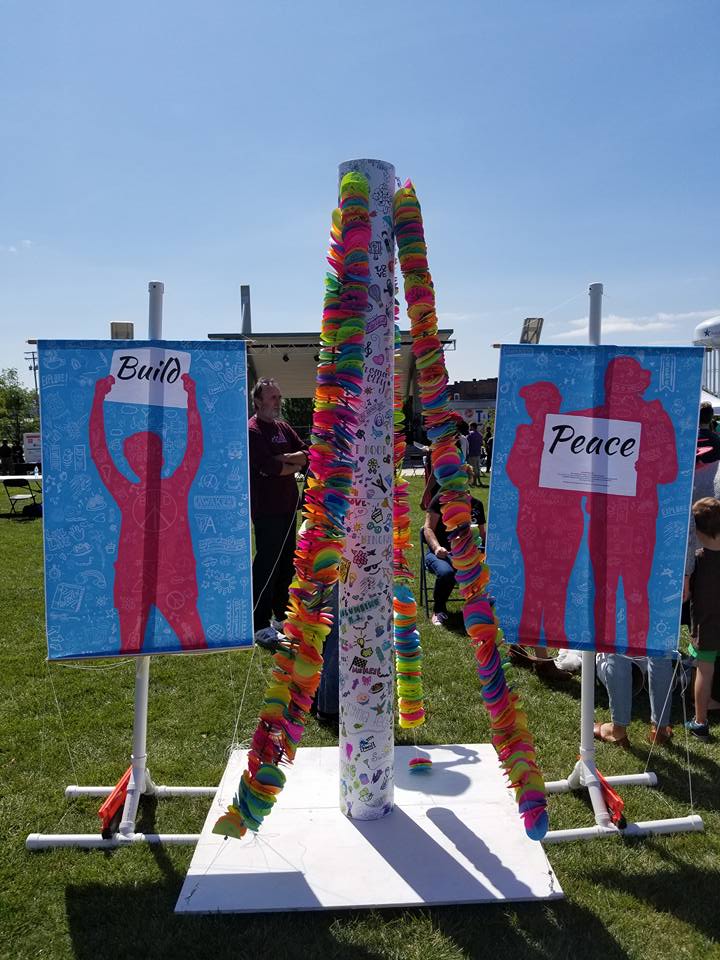 Peace pole with banners reading "Build Peace"