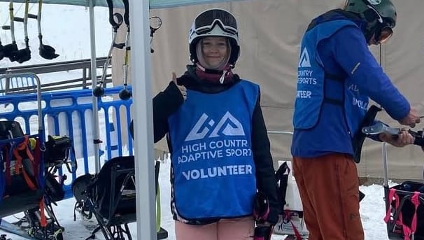 A member is getting ready with her gear to help with high country adaptive sports. 