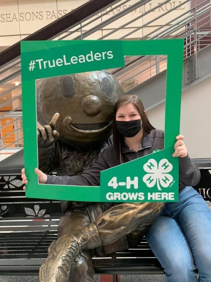 Student sitting with Brutus statue holding a 4-H frame in the Union