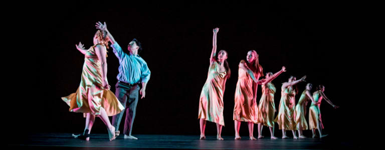 Students in gold dresses dancing in a line