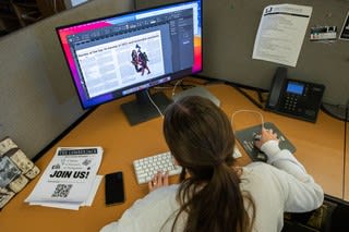 A student works on an article in the newsroom