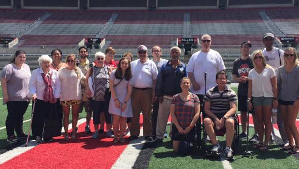 A group of people posed in the center of OSU's football field 