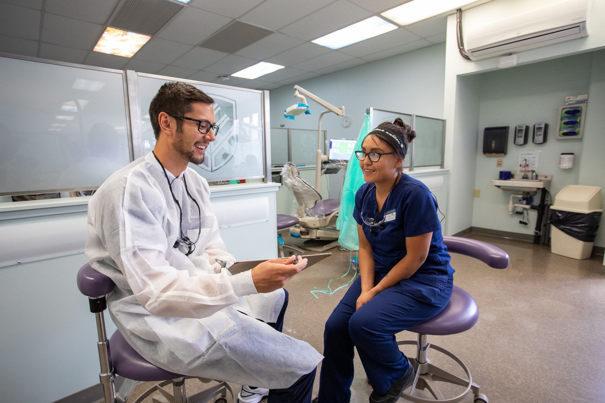 Two Dental Hygiene students speaking in the Dental Hygiene Lab.