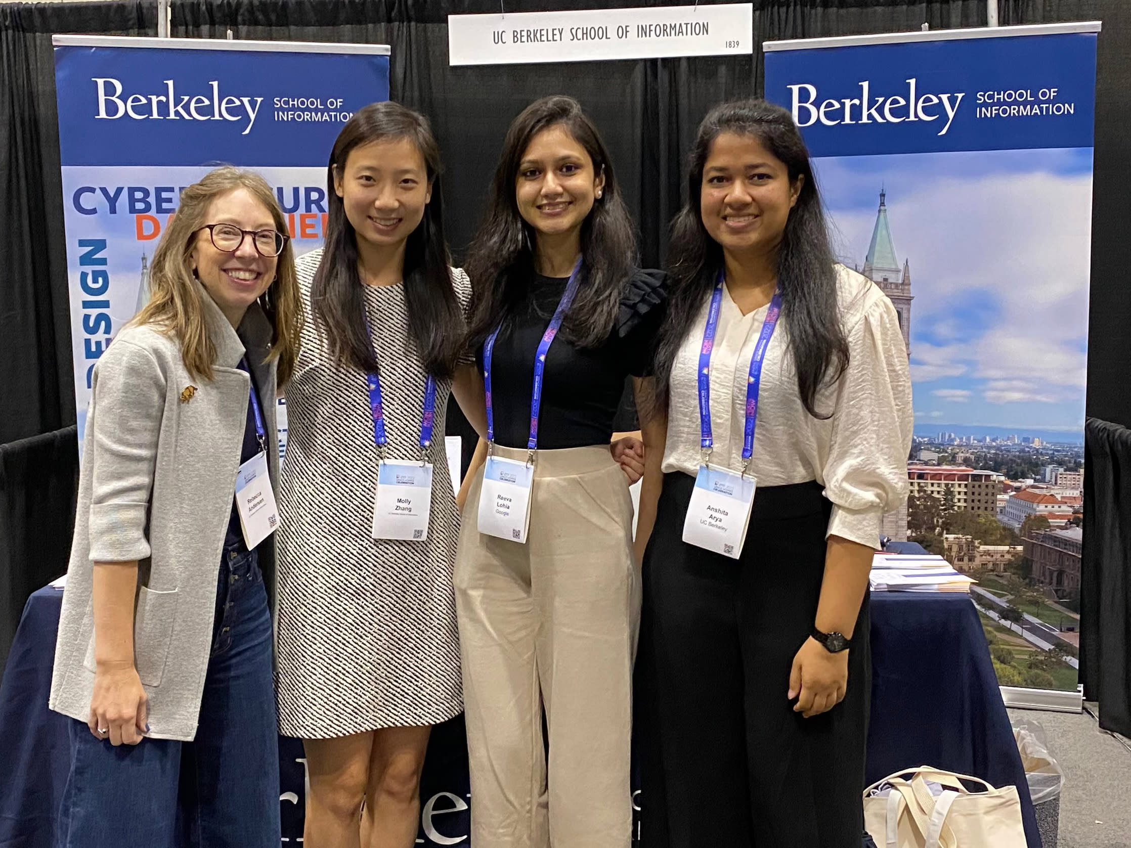 group of 4 women smiling for photo with UC Berkeley banners behind them