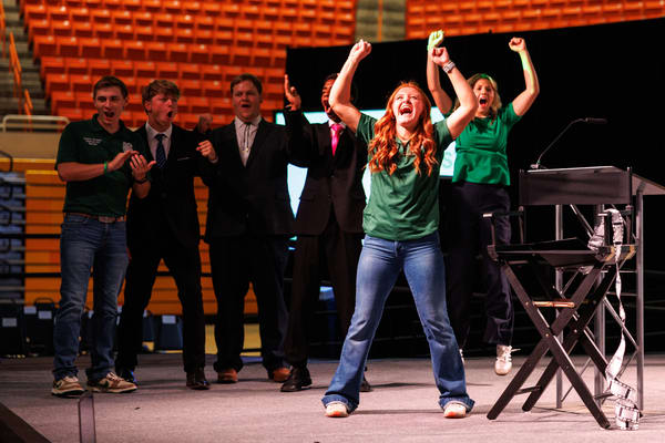 A 4-H youth with arms in celebration