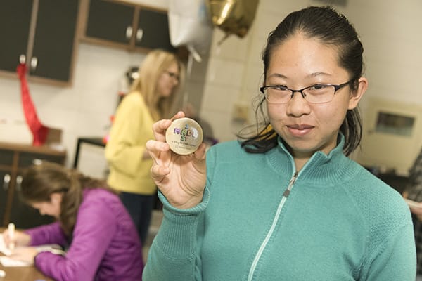 Student holding button