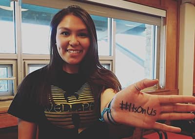 Student with #It's On Us written on her hand